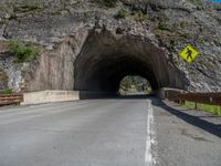 a road goes into a tunnel and through the hill to the other side of it