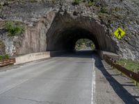 a road goes into a tunnel and through the hill to the other side of it