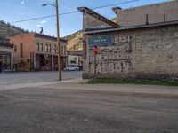 a red fire hydrant sitting in front of an old store window and building next to an open air field