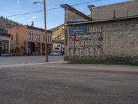 a red fire hydrant sitting in front of an old store window and building next to an open air field