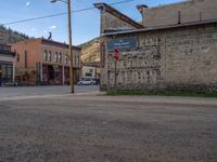 a red fire hydrant sitting in front of an old store window and building next to an open air field