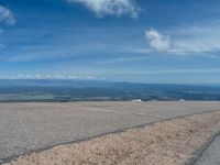 the man is at the top of a mountain on skis with mountains in the background