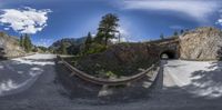 this is a wide angle looking down at the tunnel and road from below on a sunny day