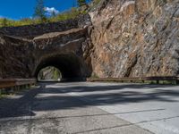 a road goes into a tunnel and through the hill to the other side of it