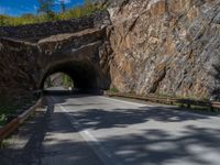 a road goes into a tunnel and through the hill to the other side of it