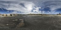 a fish eye view of a big dirt field and some houses on top of the hill