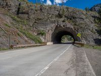 a road goes into a tunnel and through the hill to the other side of it