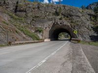 a road goes into a tunnel and through the hill to the other side of it