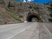 a road goes into a tunnel and through the hill to the other side of it