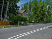 an empty street lined with trees and a mountain range in the distance in the back