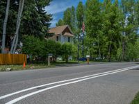 an empty street lined with trees and a mountain range in the distance in the back