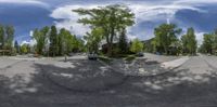 a panoramic view of a tree lined street from inside a fish eye lens