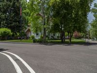 an empty street lined with trees and a mountain range in the distance in the back