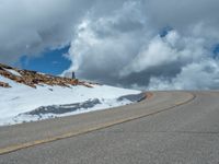 the man is at the top of a mountain on skis with mountains in the background