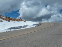 the man is at the top of a mountain on skis with mountains in the background