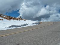 the man is at the top of a mountain on skis with mountains in the background