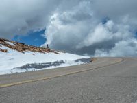 the man is at the top of a mountain on skis with mountains in the background