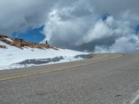 the man is at the top of a mountain on skis with mountains in the background