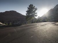 this is an image of a country road taken at sunset time in the valley, and the sun is shining on the ground