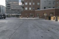 a parking lot with an empty fire hydrant in front of tall buildings and apartments