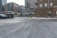 a parking lot with an empty fire hydrant in front of tall buildings and apartments