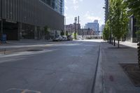 a city street with cars parked in front of the buildings and the sidewalk is empty, on a sunny day