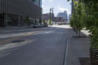 a city street with cars parked in front of the buildings and the sidewalk is empty, on a sunny day