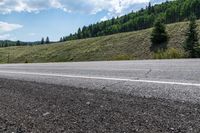 a person riding on the road with their skis down the side of the mountain