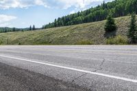 a person riding on the road with their skis down the side of the mountain