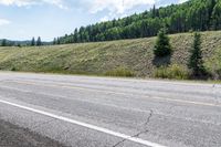 a person riding on the road with their skis down the side of the mountain