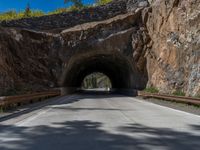 a road goes into a tunnel and through the hill to the other side of it