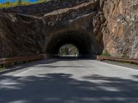 a road goes into a tunnel and through the hill to the other side of it