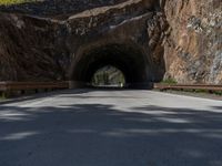 a road goes into a tunnel and through the hill to the other side of it