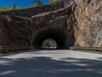 a road goes into a tunnel and through the hill to the other side of it