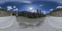 a fish eye lens shows the view of a winding road and the mountains in the distance