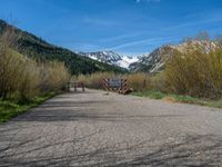 an open gate sits behind a warning sign on the side of the road that's blocked off