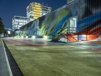 a colorful building with an art piece on the wall behind it and lights around it