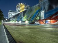 a colorful building with an art piece on the wall behind it and lights around it