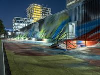 a colorful building with an art piece on the wall behind it and lights around it