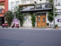 several scooters are parked in front of a building with flowers on the outside