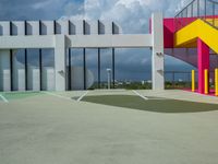 a colorful building with colorful stairs and a parking lot in front of it, as well as a staircase