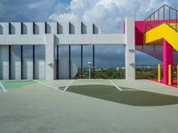 a colorful building with colorful stairs and a parking lot in front of it, as well as a staircase