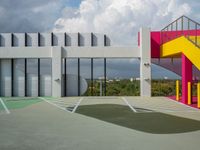 a colorful building with colorful stairs and a parking lot in front of it, as well as a staircase