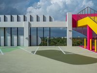 a colorful building with colorful stairs and a parking lot in front of it, as well as a staircase