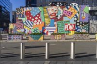 a woman walking by a very colorful building with a mural in the background at an urban area