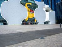 an empty plaza that features a colorful building with many windows and an abstract graphic on the wall