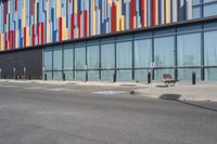 a picture of the street outside a multi - color building with markings on it's parking spaces