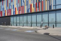 a picture of the street outside a multi - color building with markings on it's parking spaces