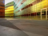 three colorful buildings reflecting each other in a large courtyard, and a bicycle lane underpass