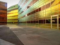 three colorful buildings reflecting each other in a large courtyard, and a bicycle lane underpass